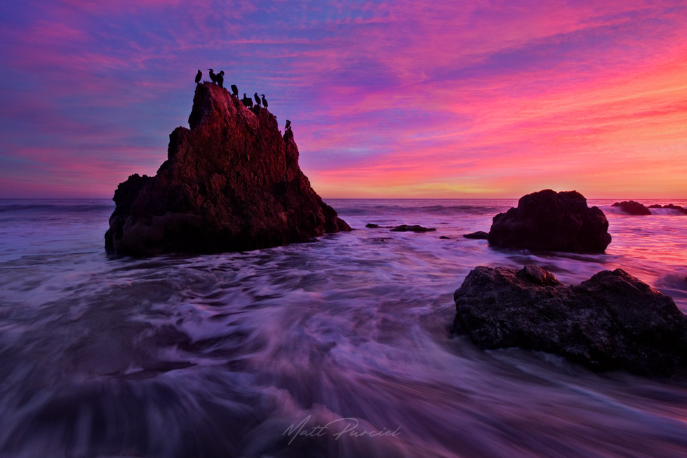 El Matador Beach in Malibu with dramatic sea stacks, cormorants, and fiery winter sunset over the California coast
