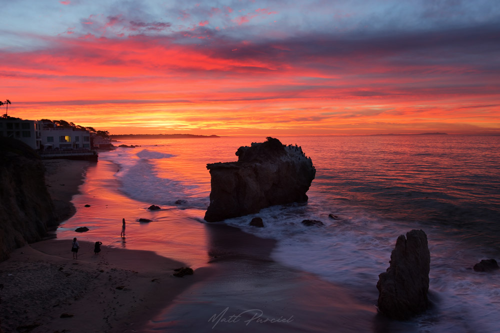 Malibu sunrise along the California coast with fiery sky over dramatic coastal cliffs
