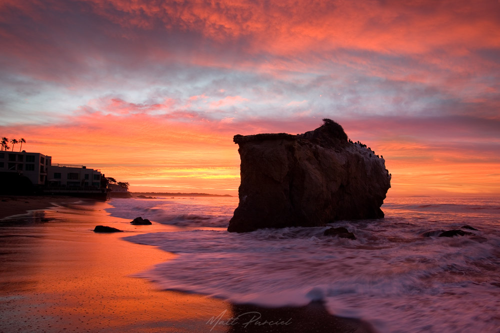 Southern California beach sunrise at El Matador State Beach in Malibu with glowing sky and dramatic cliffs